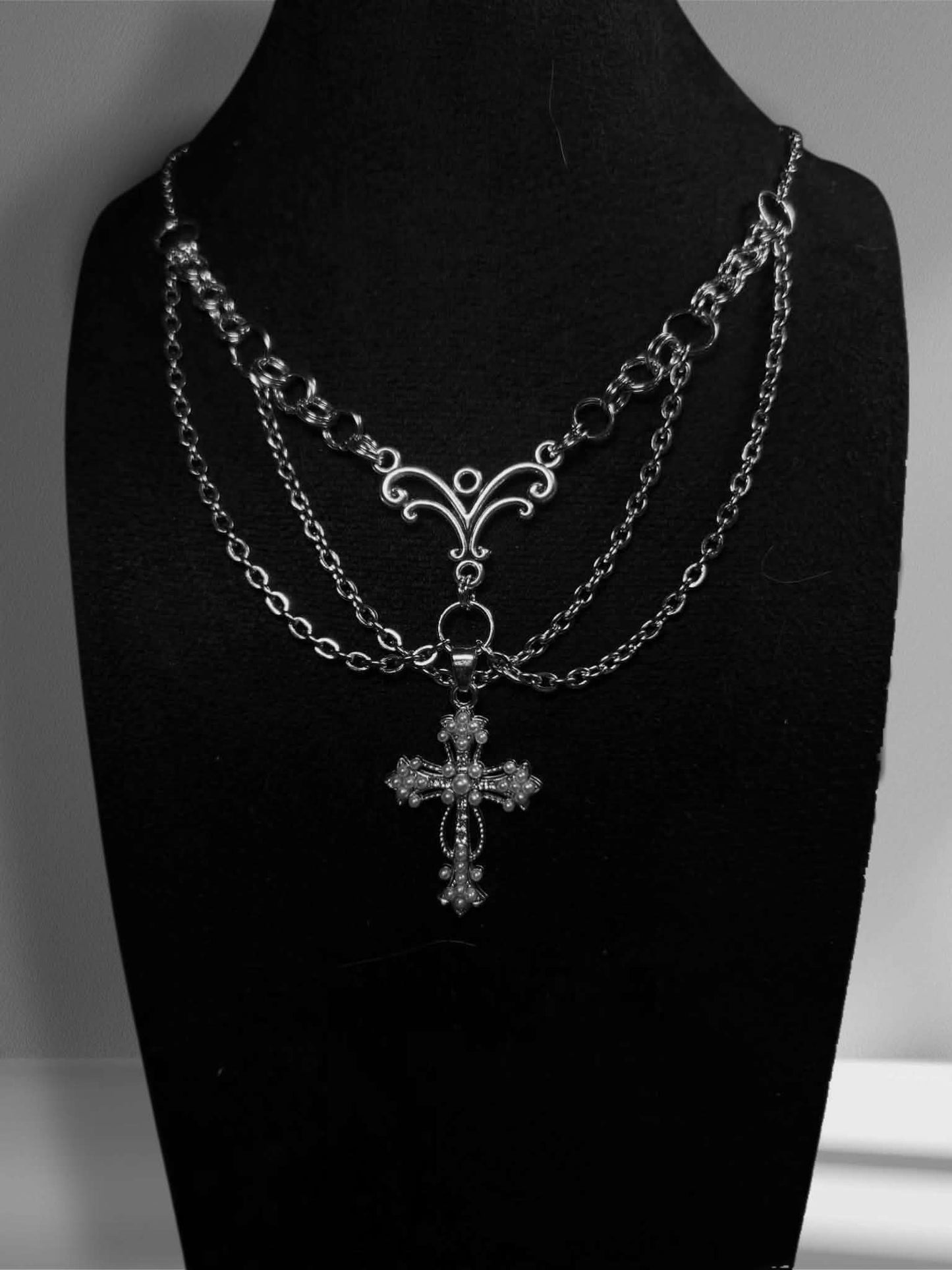 Handmade necklace with a detailed cross and extra chains