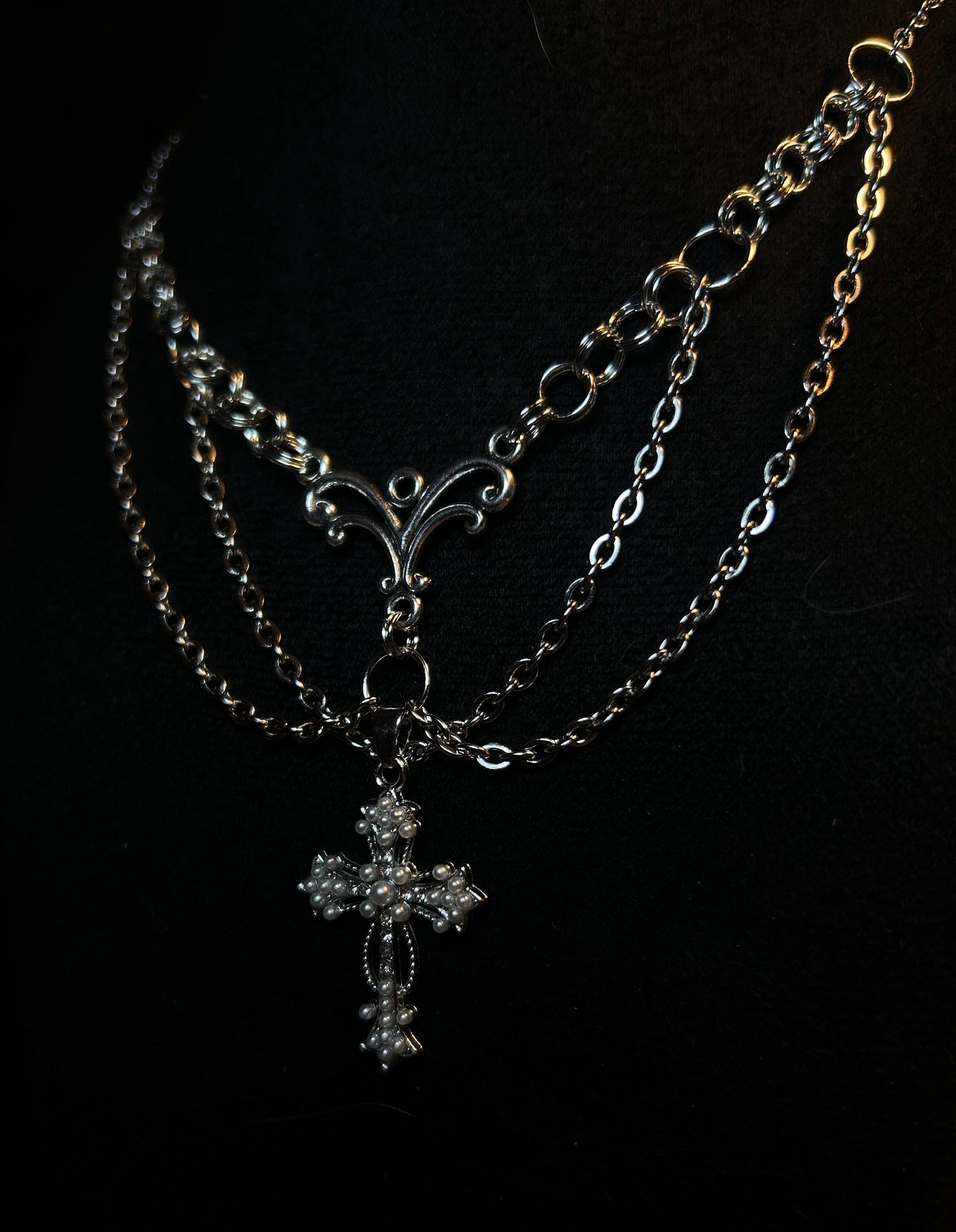 Handmade necklace with a detailed cross and extra chains